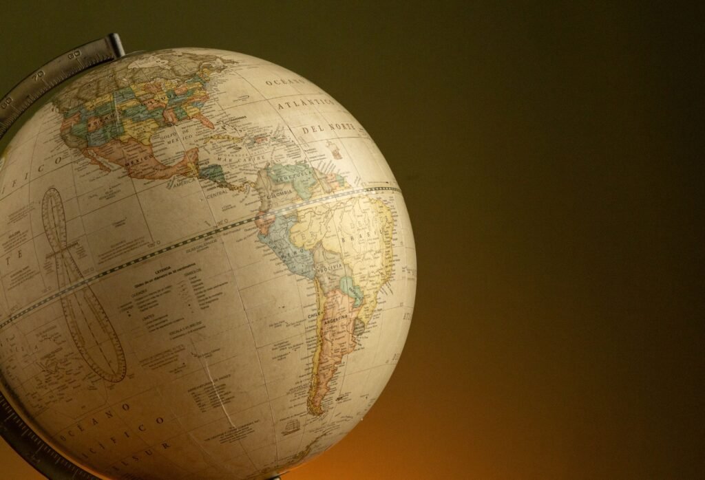 A vintage globe highlighting North and South America, set against a warm background.